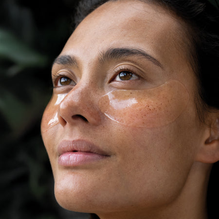 Model wears Hydrogel Eye masks under her eyes as she looks on into the distance.